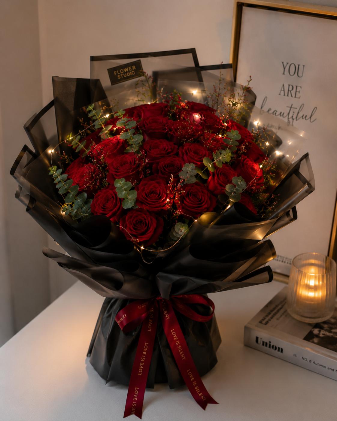 Twenty-five red roses with a glowing ribbon