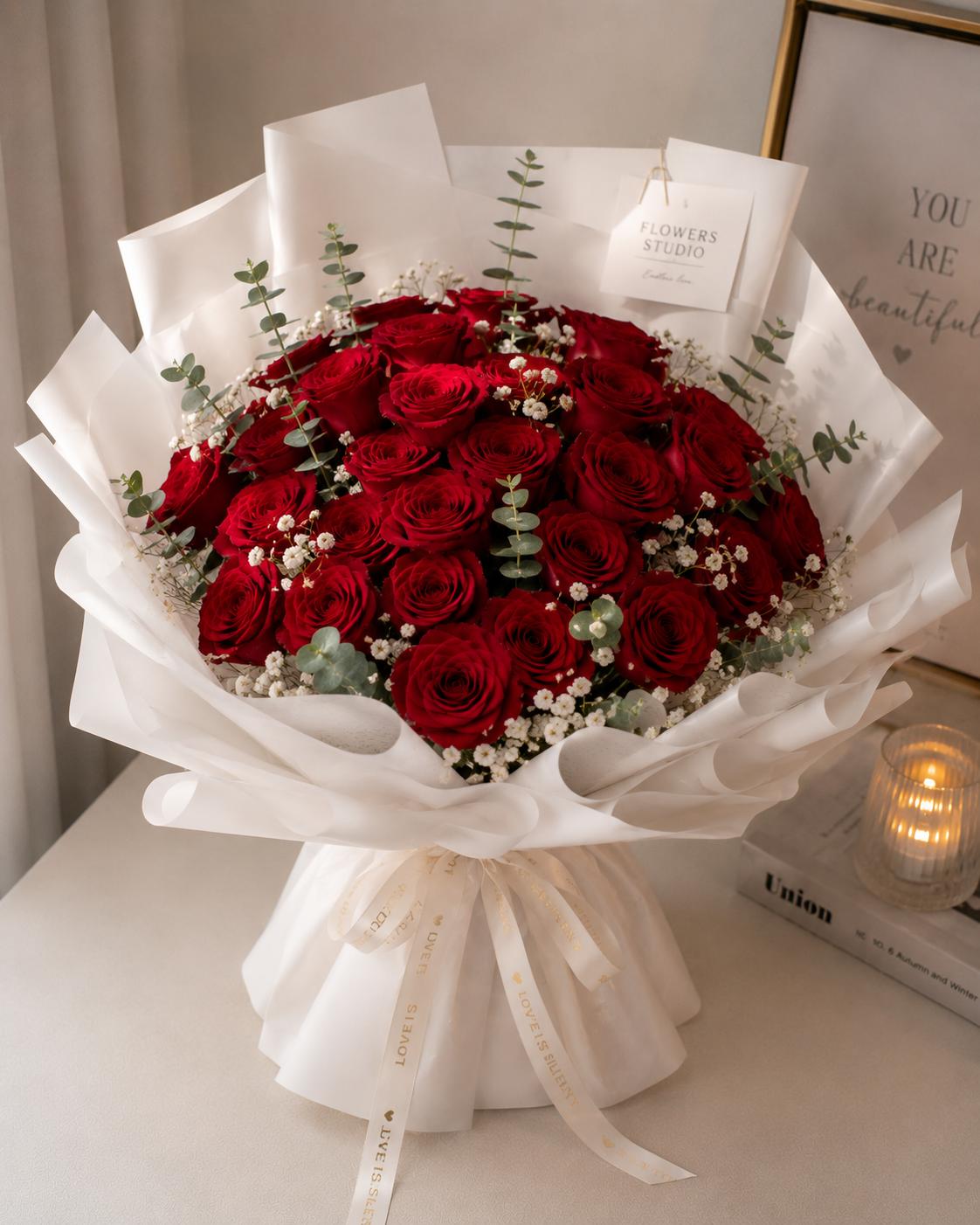 Twenty-five red roses in white wrapping with large bows